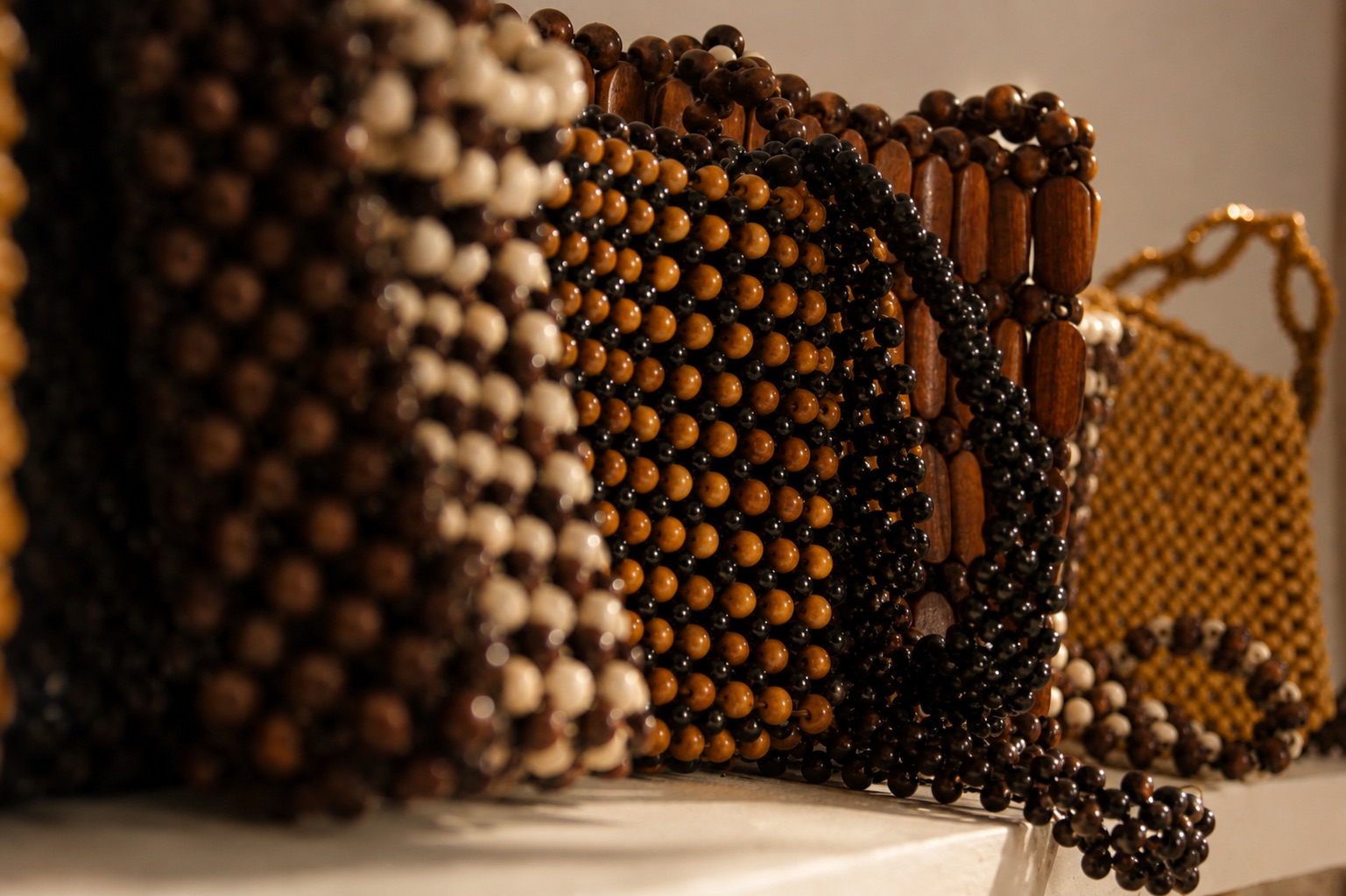 Handcrafted beaded bags arranged together in warm directional light.