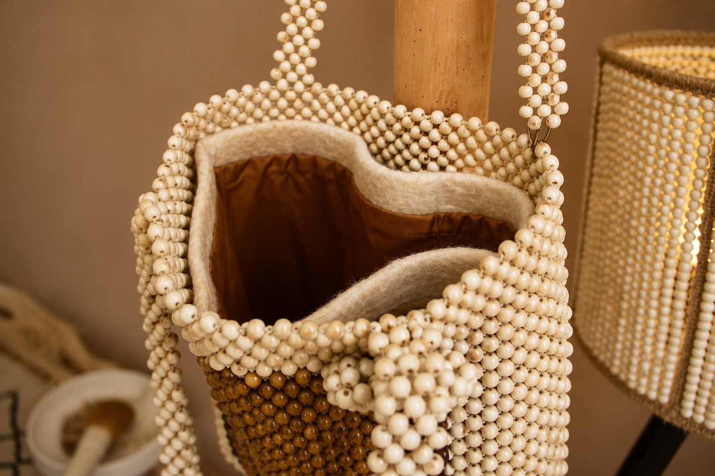Close view into the opening and handle construction of a beaded tote.
