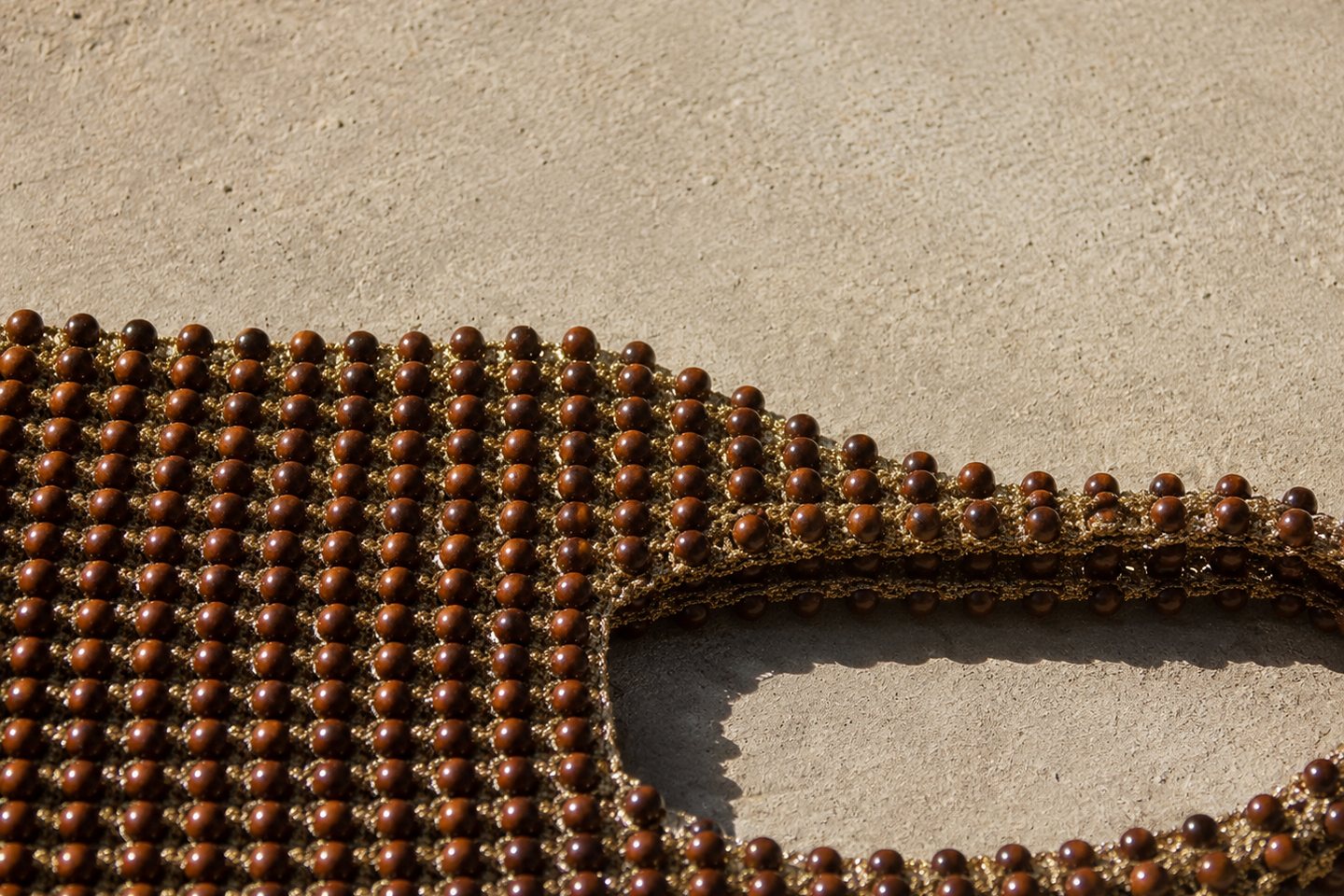 An extreme close view of interlocked wooden beads on stone.